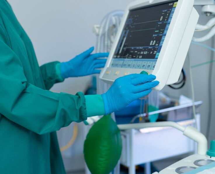 Midsection,Of,Surgeon's,Gloved,Hands,Operating,Computerised,Medical,Equipment,In